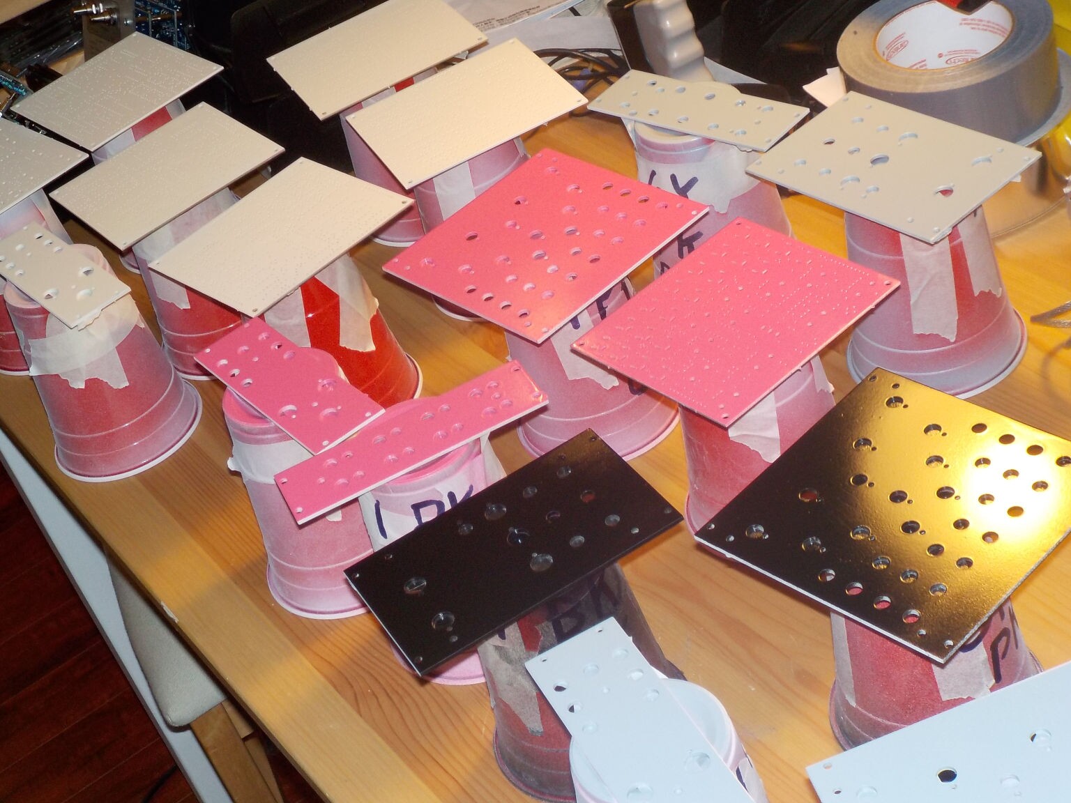 panels with pink, black, and grey paint, and a few with only white primer